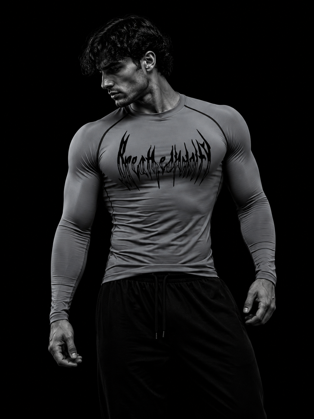 Homme portant le t-shirt de compression manches longues Breathedivinity gris, buste de trois-quarts sur fond noir studio.