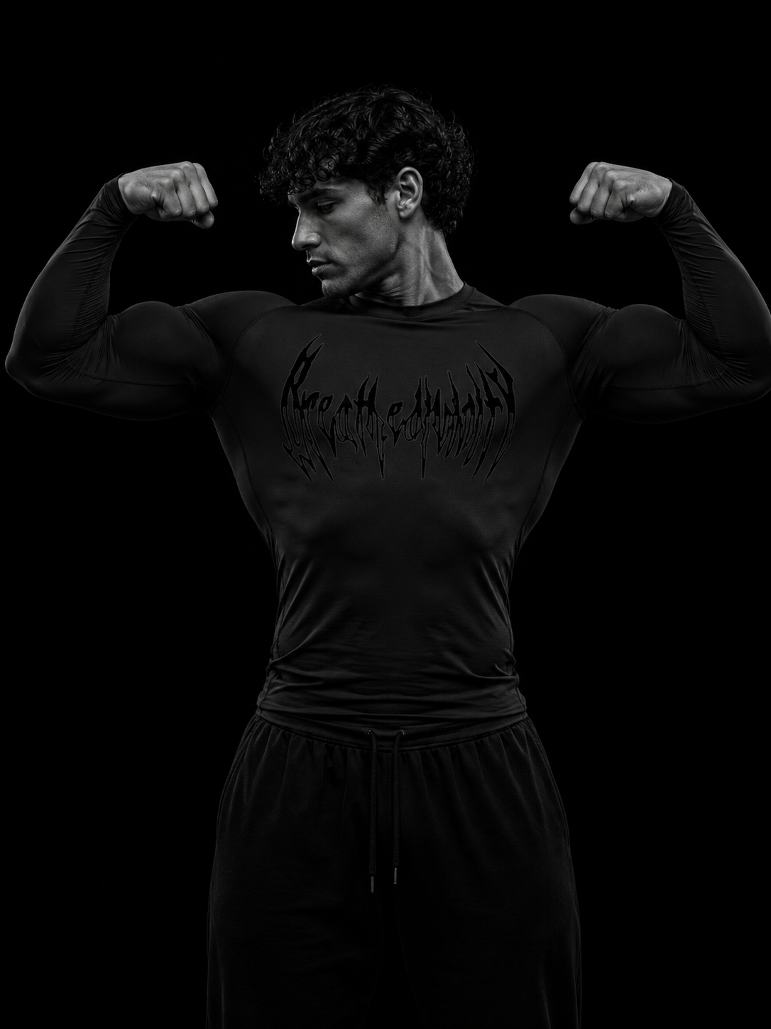 Homme musclé posant double biceps en t-shirt de compression manches longues Breathedivinity noir, vue de face, fond studio sombre