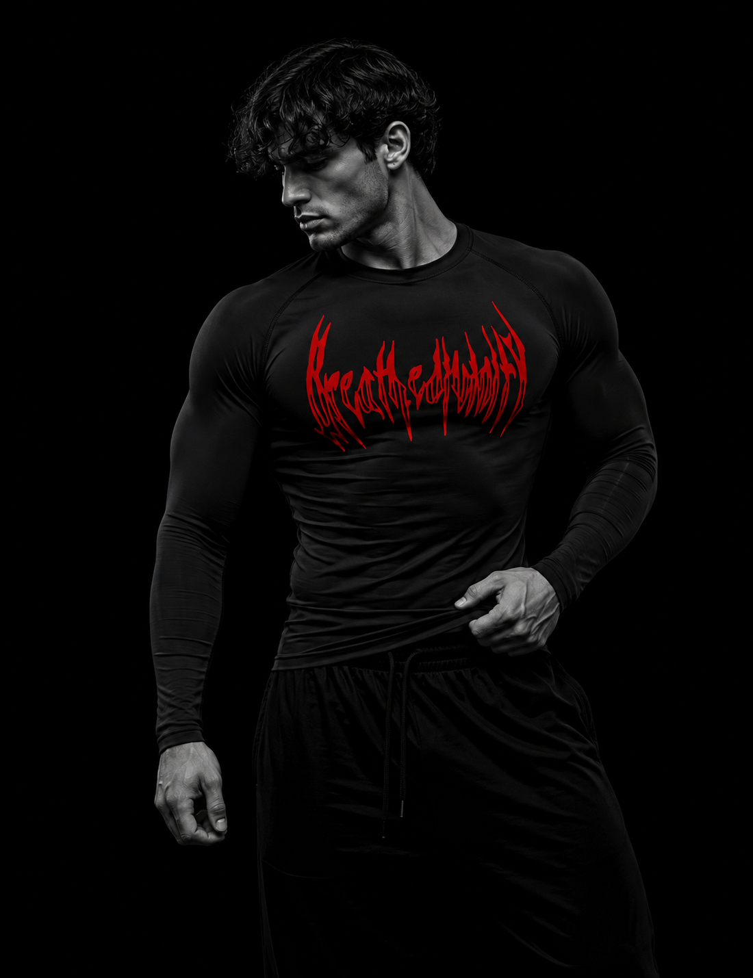 Homme musclé portant le t-shirt de compression manches longues Breathedivinity noir, logo rouge, vue de trois-quarts sur fond sombre